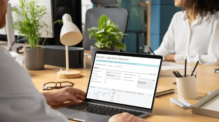 Mannn und Frau mit Laptop. auf dem Sceen das Business Central Mahnmodul